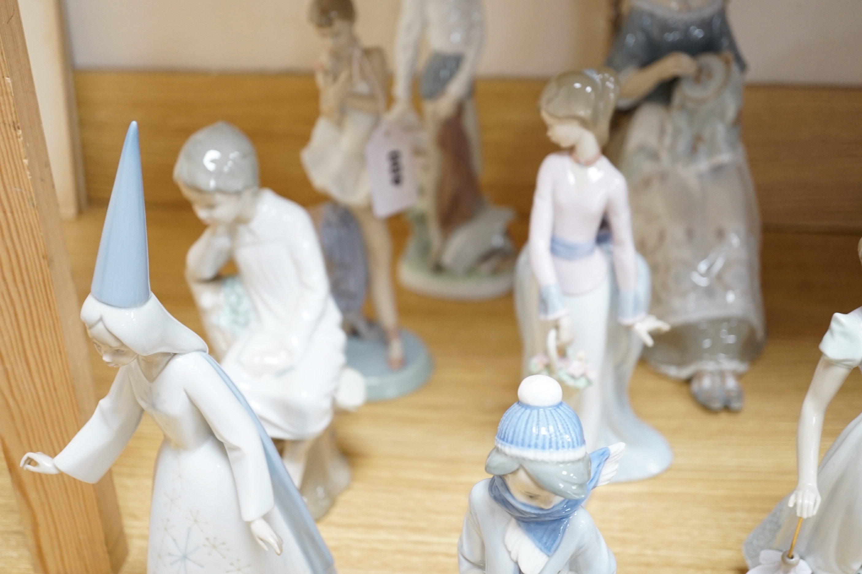 Ten Lladro figures including Don Quixote and seated lady with embroidery, the largest 30cm high